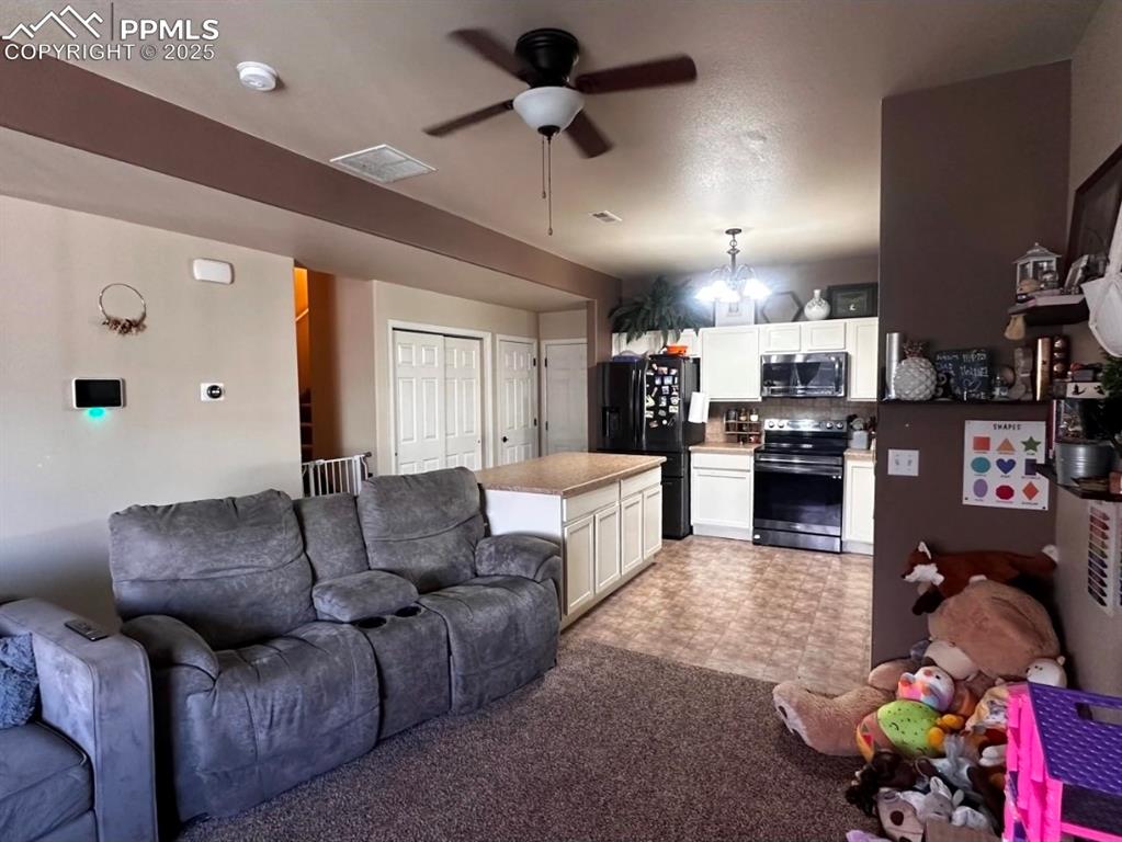 Living room featuring a ceiling fan and carpet flooring