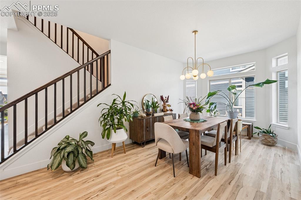 Dining space with light wood finished floors and stairway