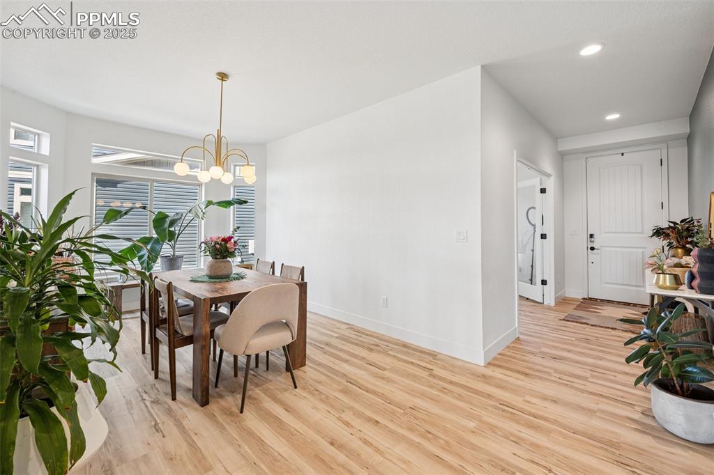 Dining space with light wood-style floors, recessed lighting, and a chandelier