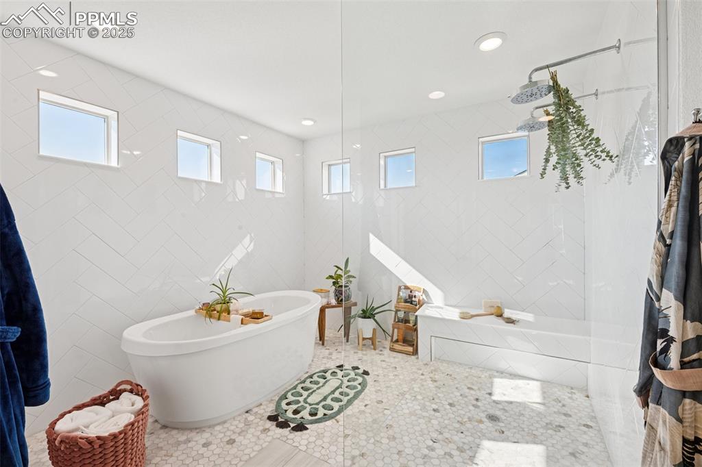 Bathroom with tile walls, a soaking tub, plenty of natural light, a walk in shower, and recessed lighting