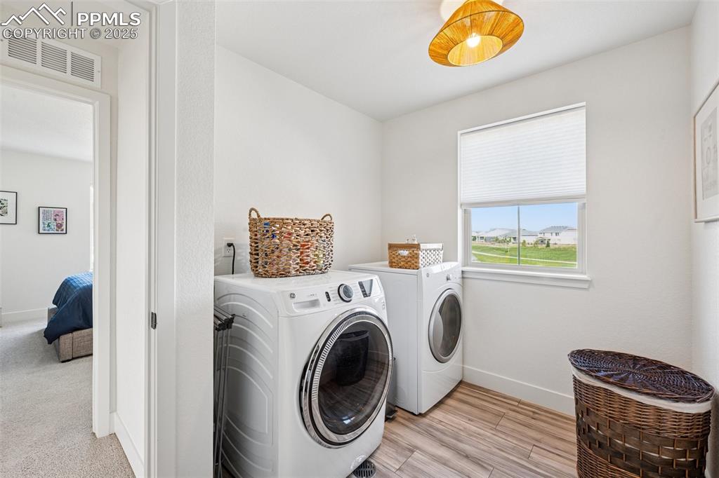 Washroom featuring separate washer and dryer and light wood-type flooring