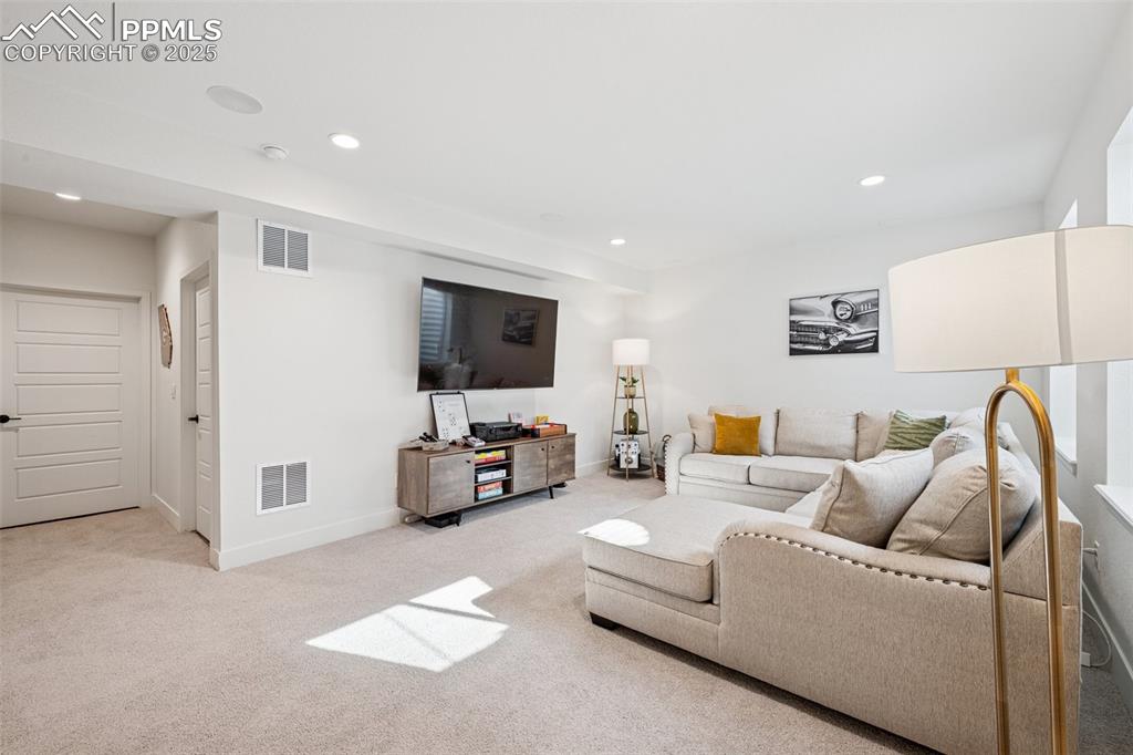 Living area with recessed lighting and light colored carpet