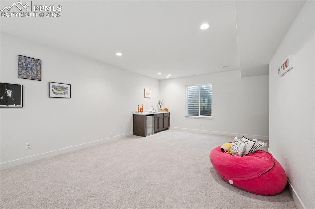 Rec room with light colored carpet and recessed lighting