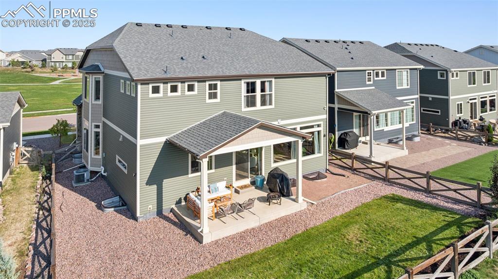 Rear view of property featuring a patio, a residential view, a fenced backyard, and a shingled roof