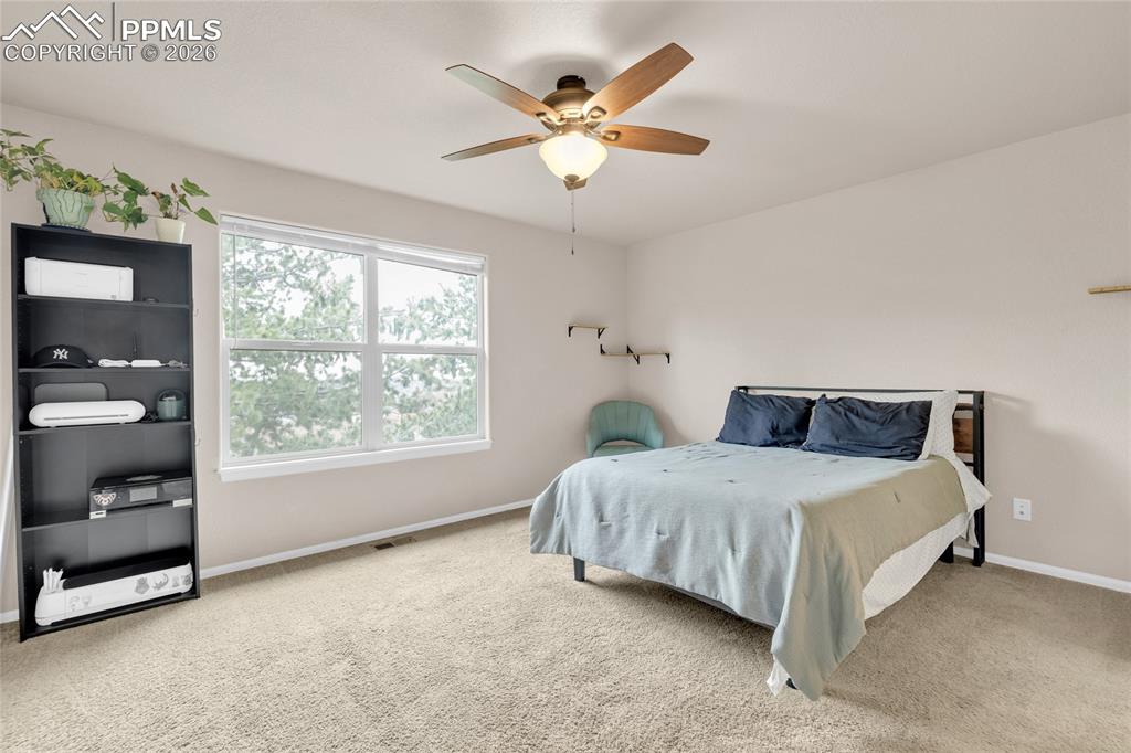 Bedroom with a ceiling fan and light colored carpet