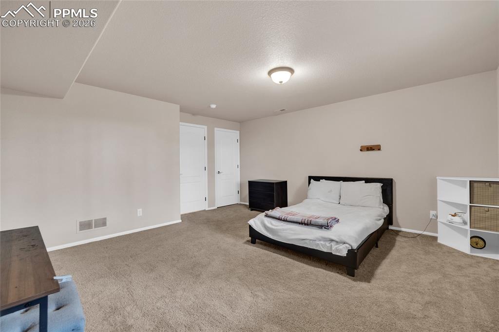 Bedroom featuring light carpet