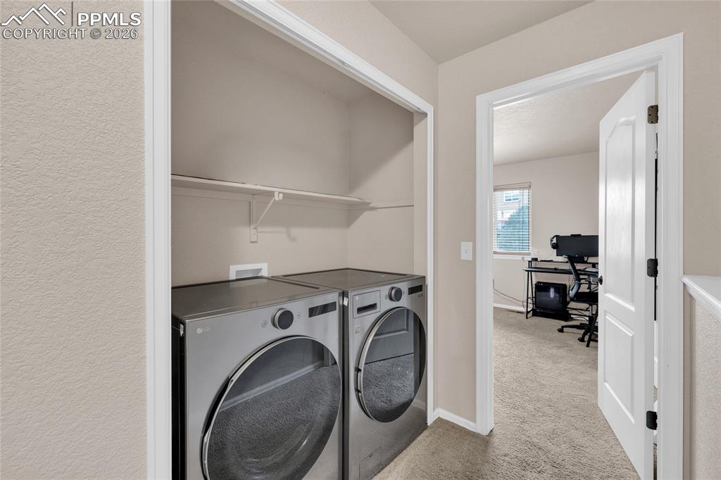 Laundry area featuring light colored carpet, an office area, and independent washer and dryer