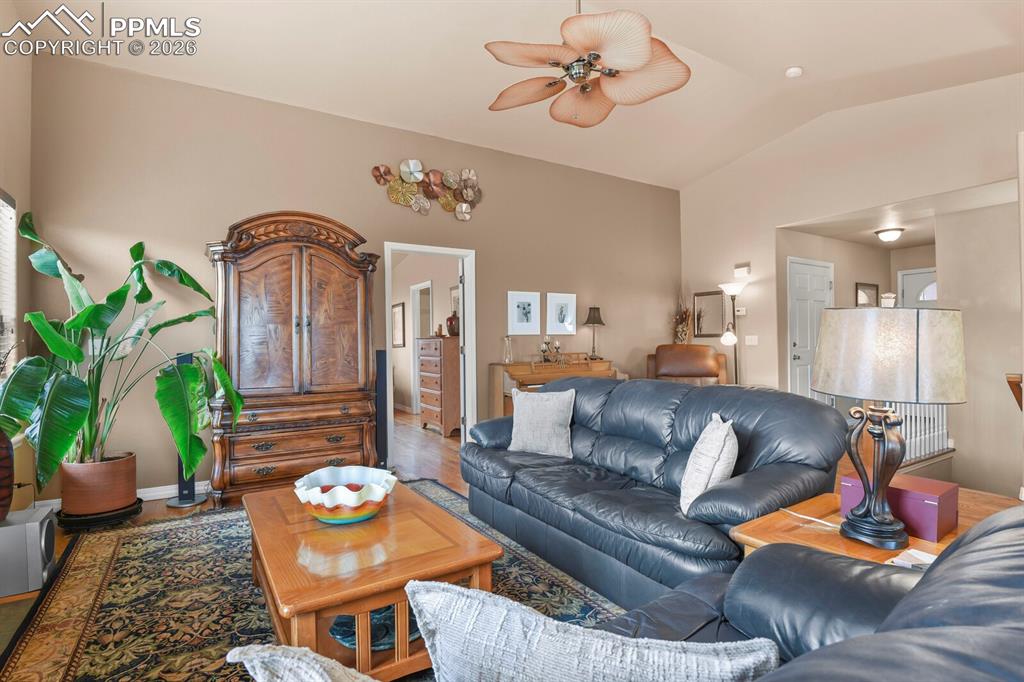 Living area from the dining area,with ceiling fan, vaulted ceiling, and hardwood wood floors.