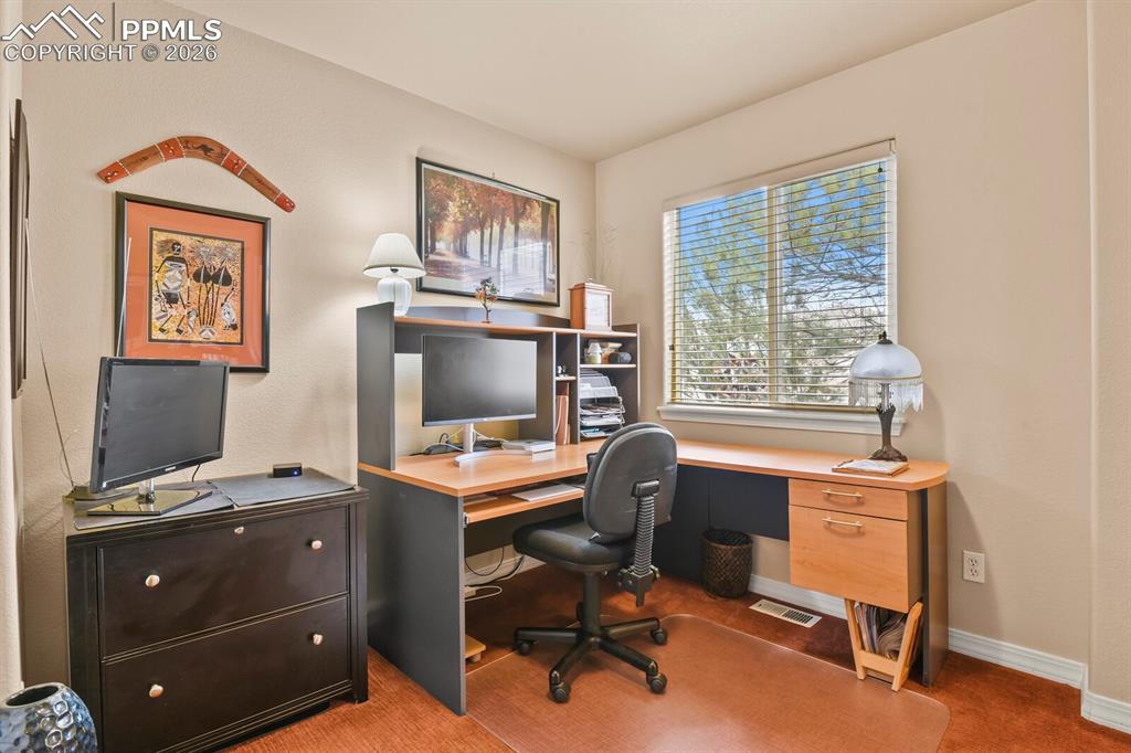 Second bedroom on the main level, currently used as an office.  Faces to the street.  Carpet.