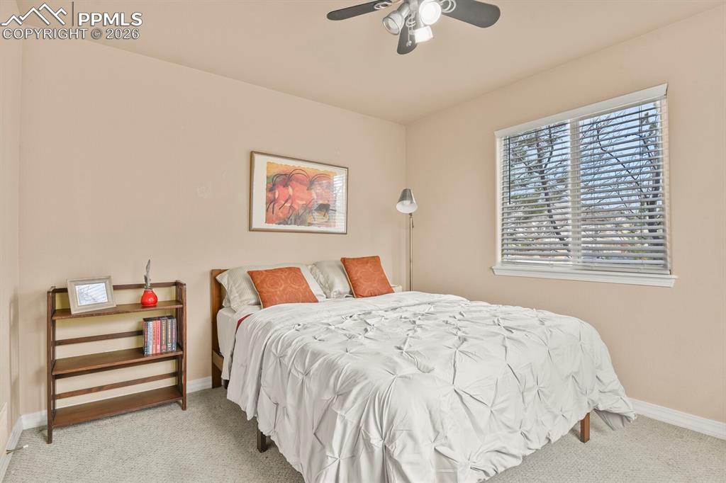 3rd bedroom on the main level featuring light carpet and ceiling fan