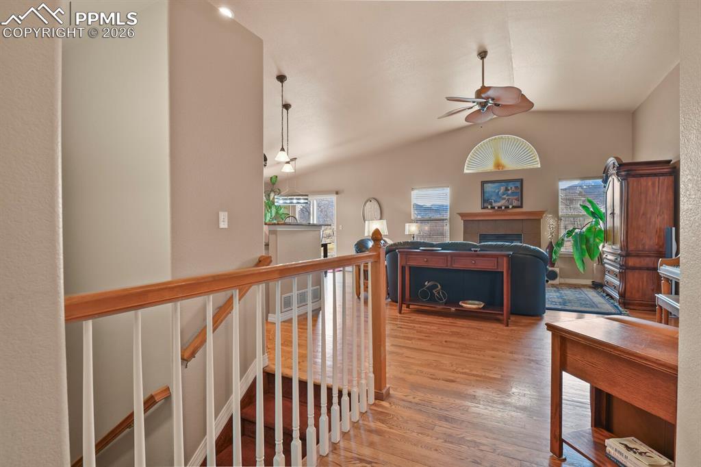 View from the front door into the living room featuring lofted ceiling, wood finished floors and mountain scenery from the windows