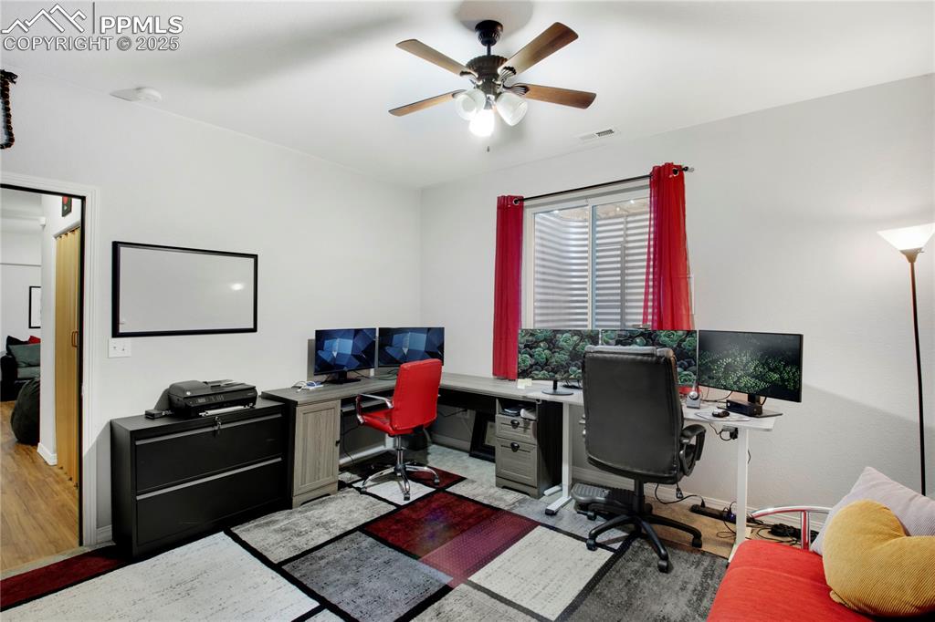 Office space featuring a ceiling fan and baseboards