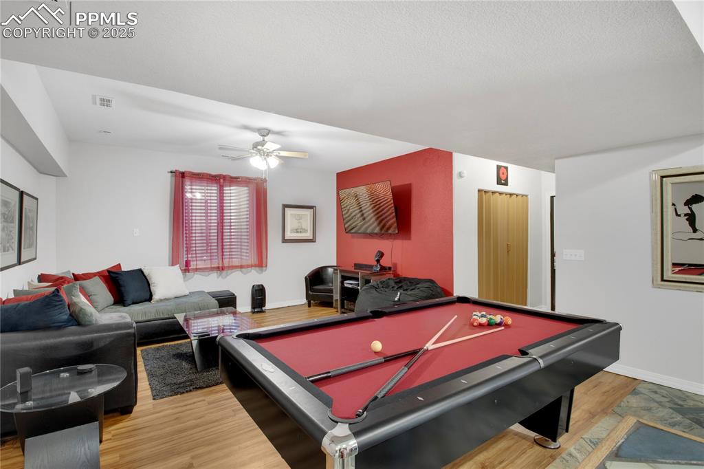Rec room featuring light wood-style flooring, a ceiling fan, pool table, and baseboards