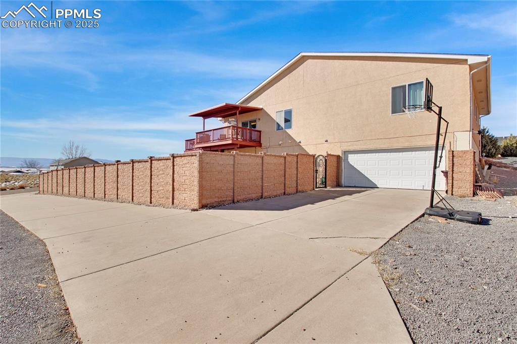 View of property exterior featuring an attached garage, concrete driveway, and stucco siding