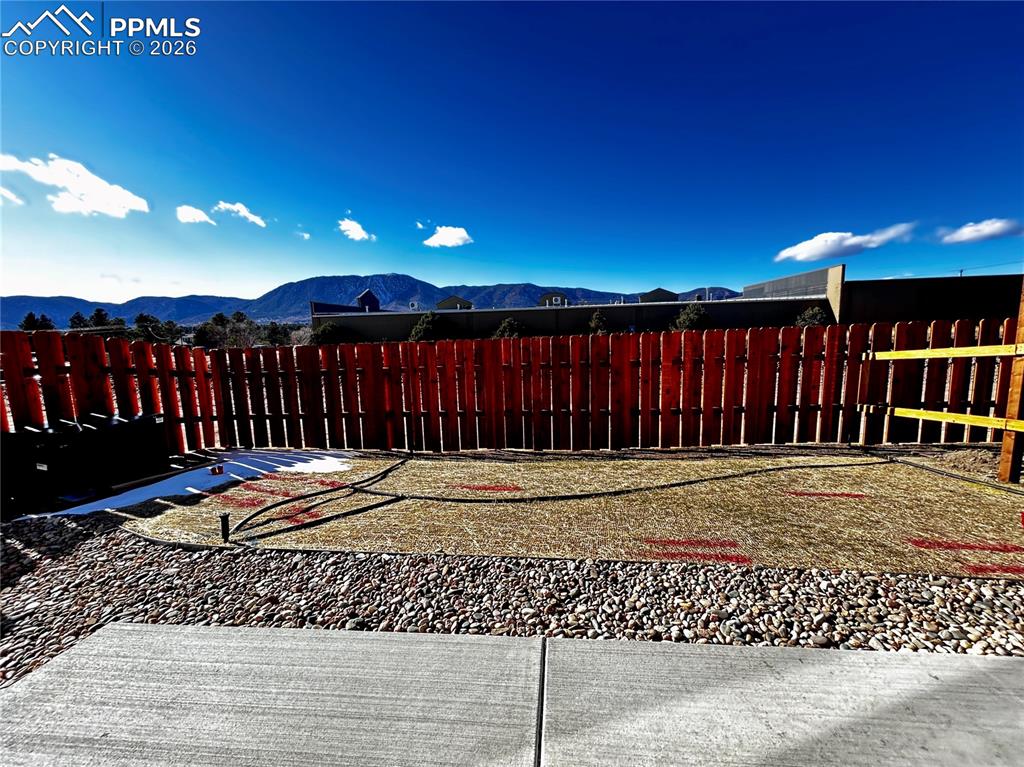 Fenced backyard featuring a mountain view