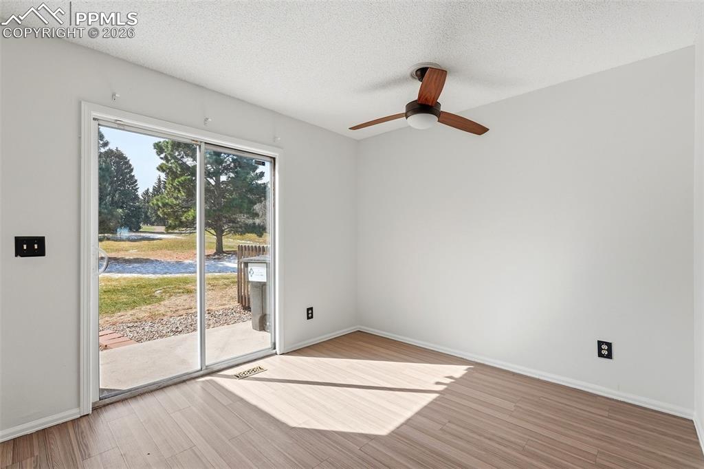 Dining room featuring light wood finished floors, a textured ceiling, and a ceiling fan