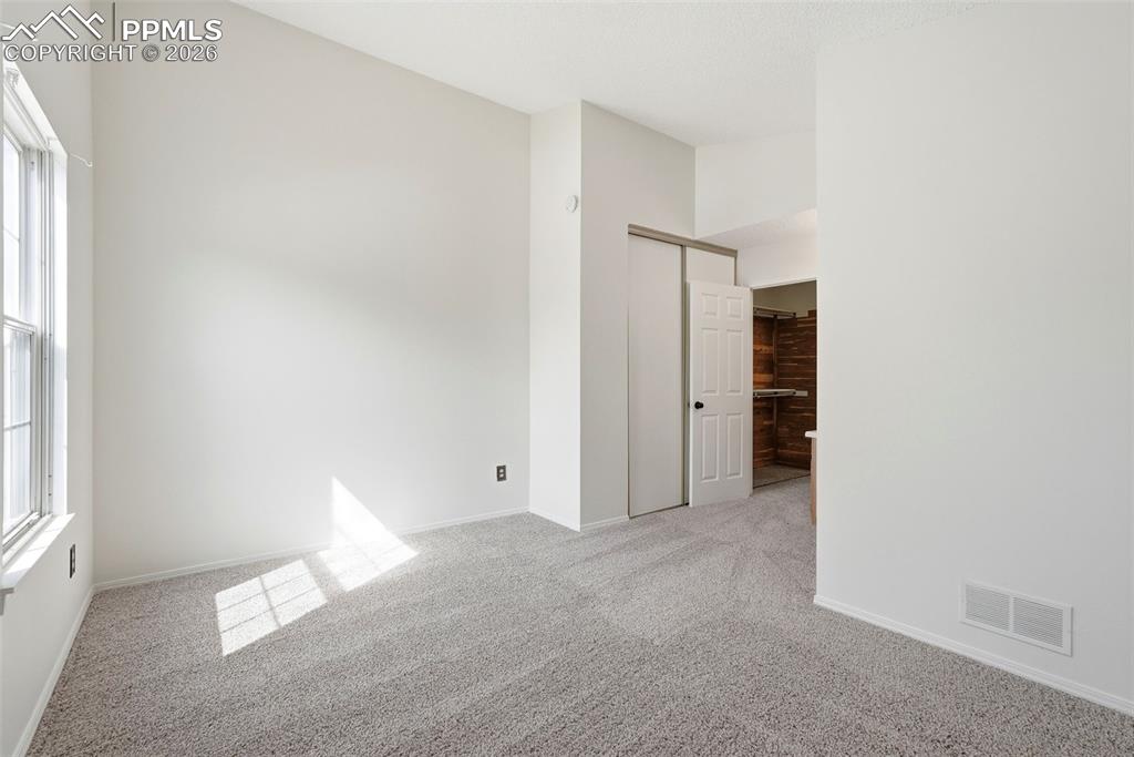 Spare room featuring light colored carpet and baseboards