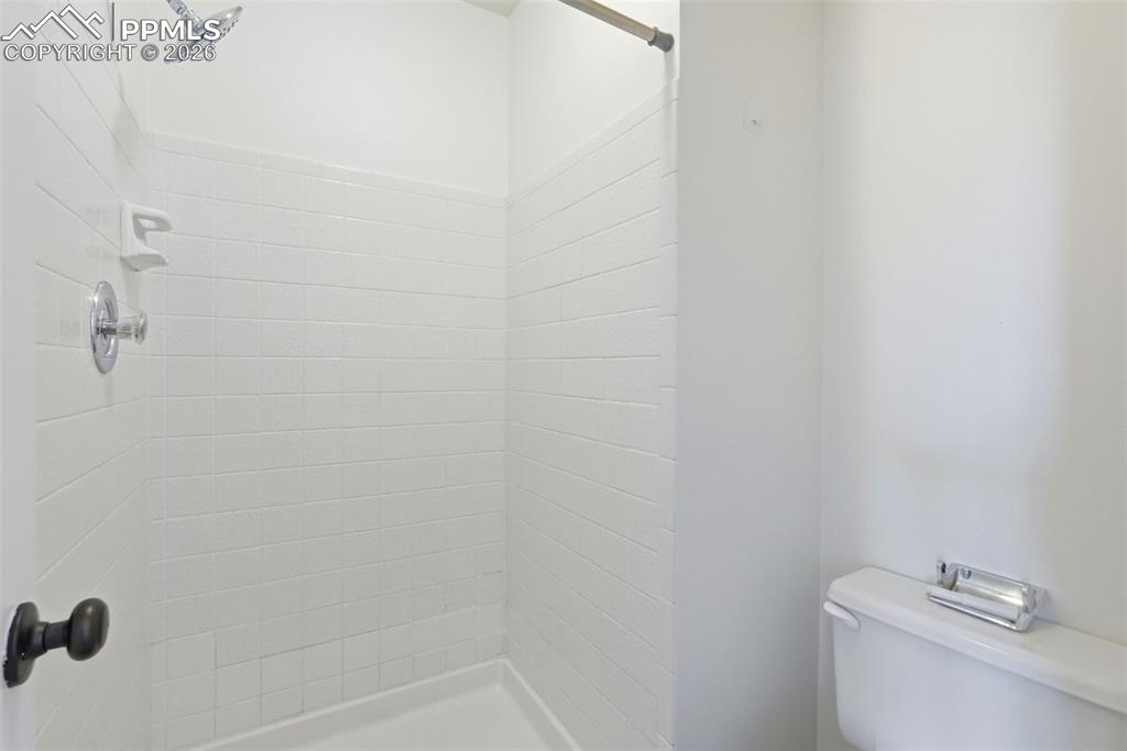 Full bathroom with toilet and a stall shower