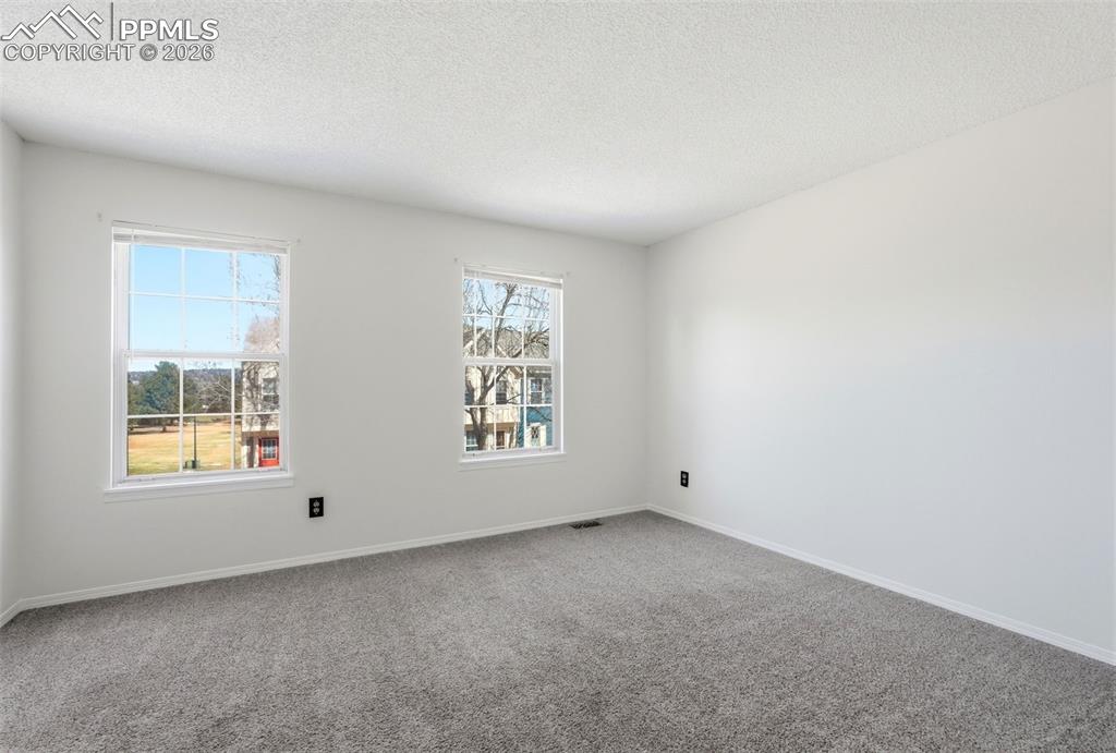 Empty room featuring carpet flooring and a textured ceiling