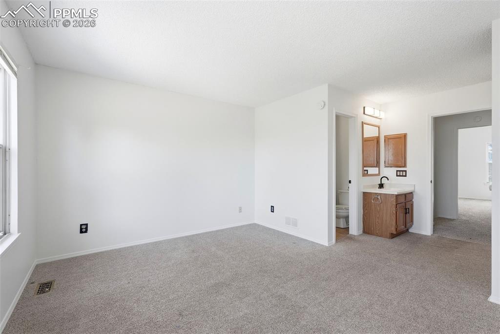 Unfurnished bedroom featuring light carpet and baseboards