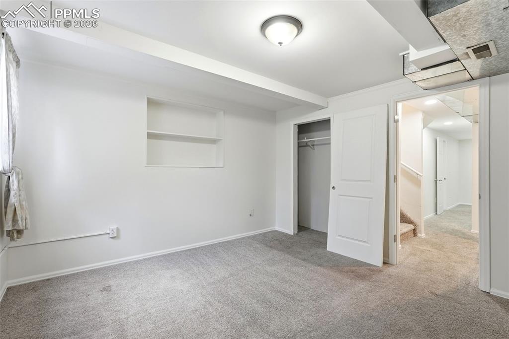 Unfurnished bedroom featuring light carpet and a closet