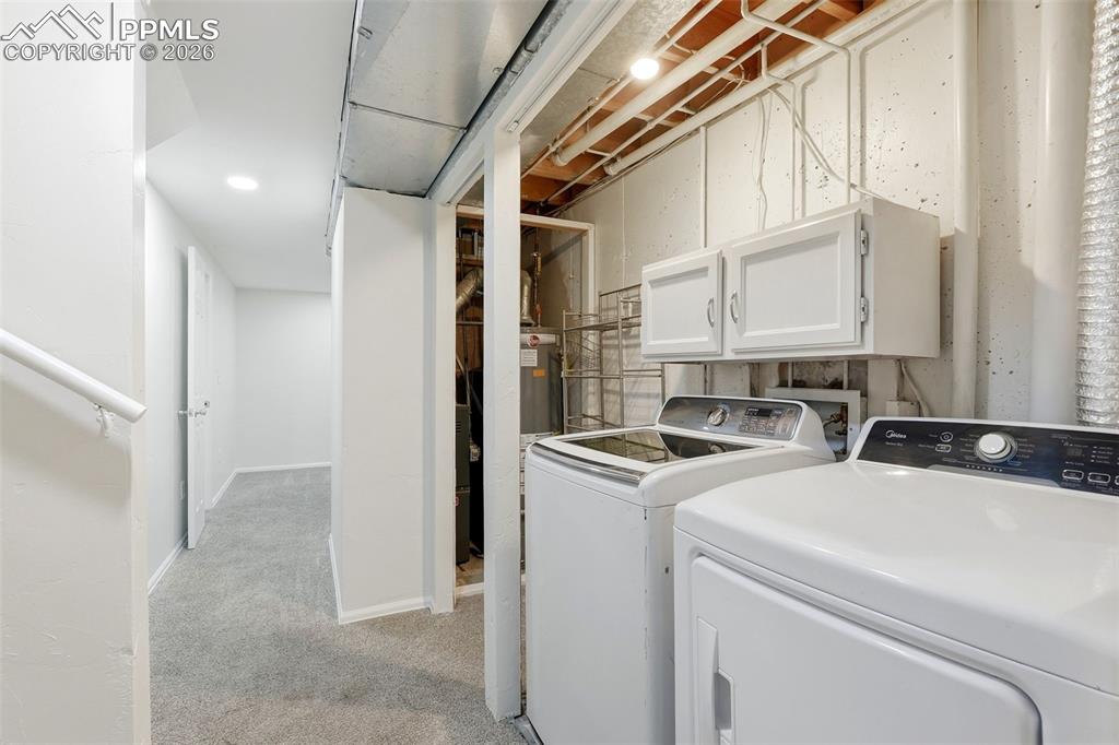 Laundry room featuring cabinet space, independent washer and dryer, light carpet, and recessed lighting