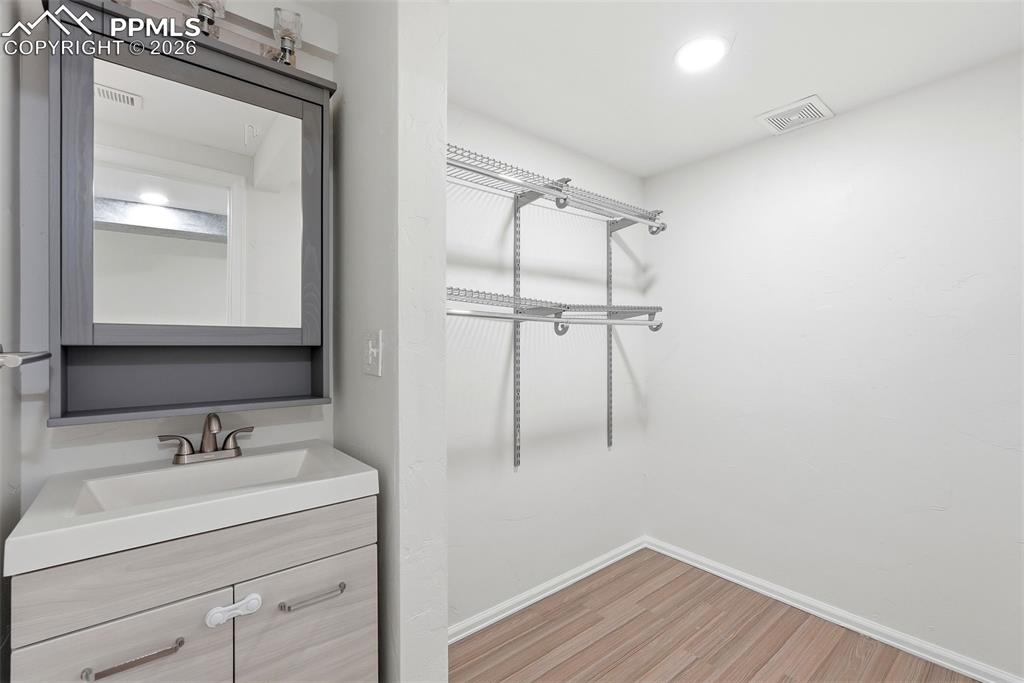 Bathroom featuring vanity, light wood finished floors, and recessed lighting