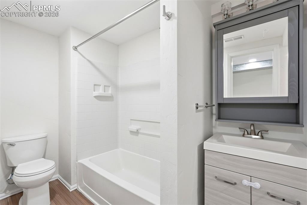 Full bathroom featuring vanity, wood finished floors, and bathing tub / shower combination