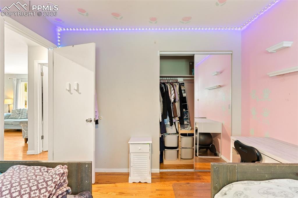 Bedroom with wood finished floors and a closet