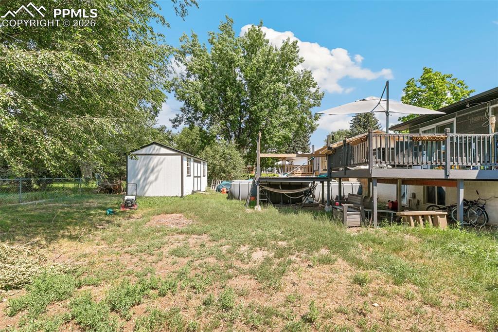 View of yard featuring a wooden deck and an outbuilding