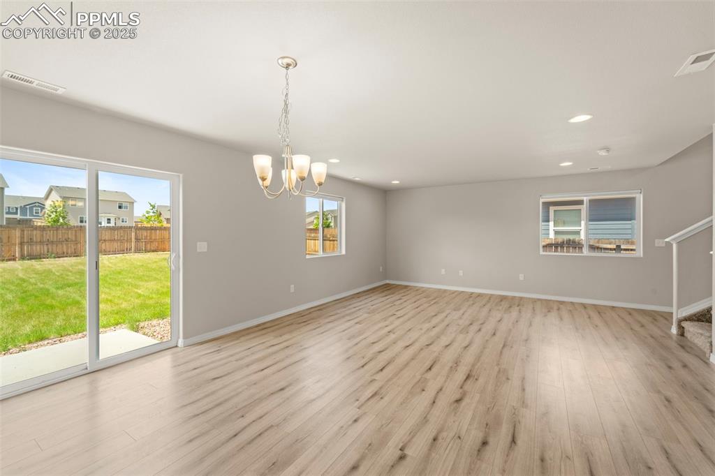 Spare room featuring light wood-style floors, a chandelier, and recessed lighting