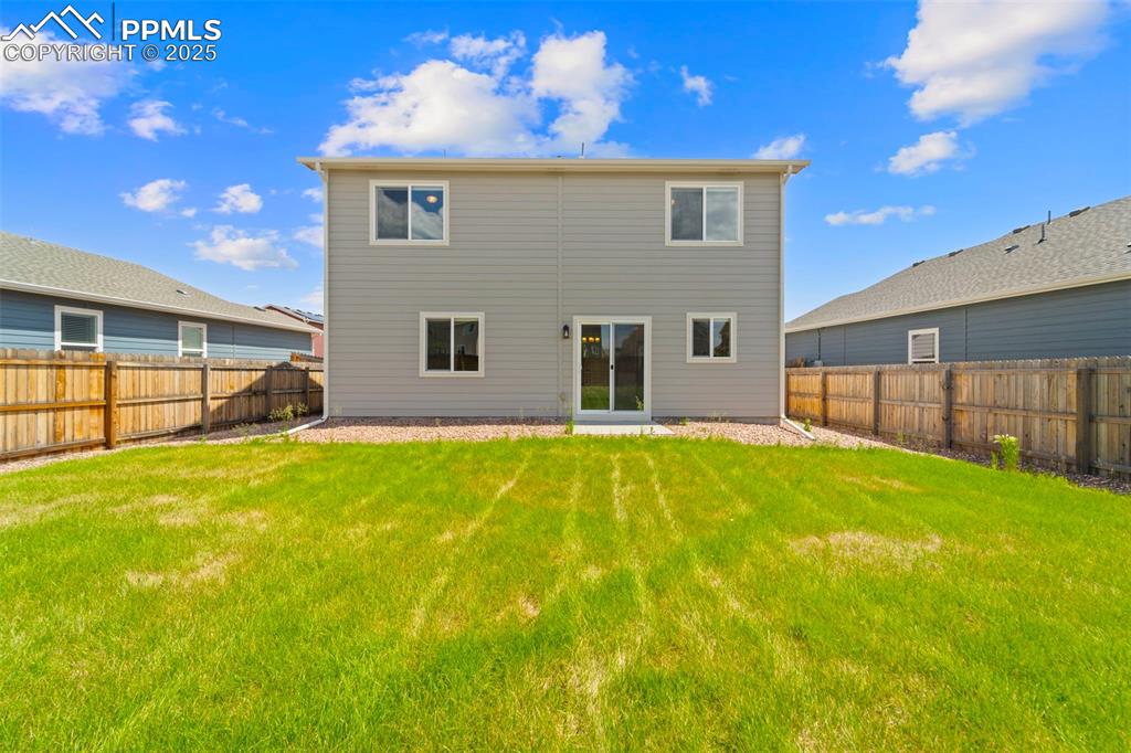 Rear view of property featuring a fenced backyard