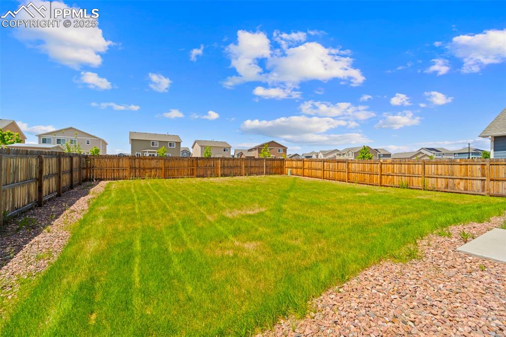 Fenced backyard featuring a residential view