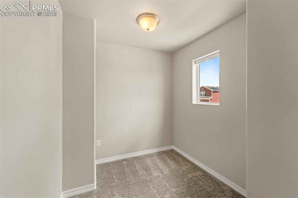 Spare room with carpet and baseboards