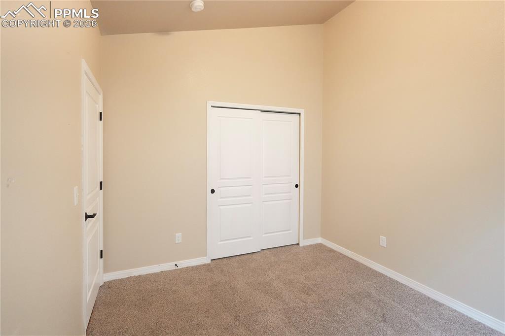Unfurnished bedroom with a closet and light colored carpet