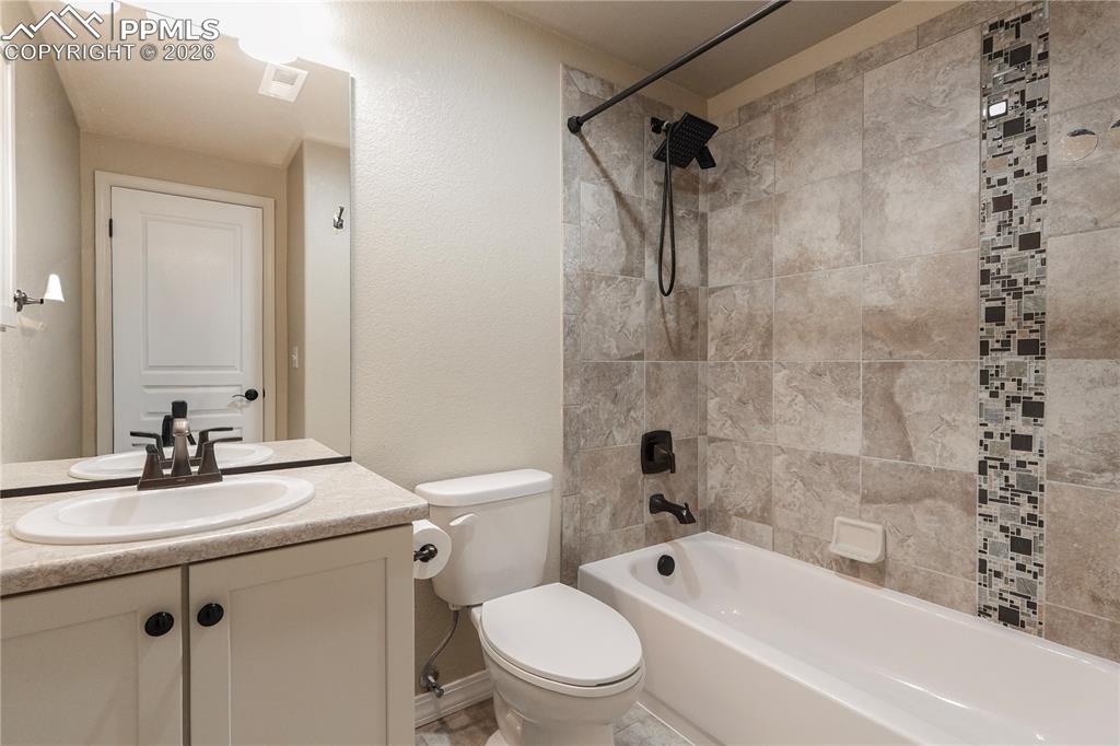 Bathroom with vanity,  shower combination, and a textured wall