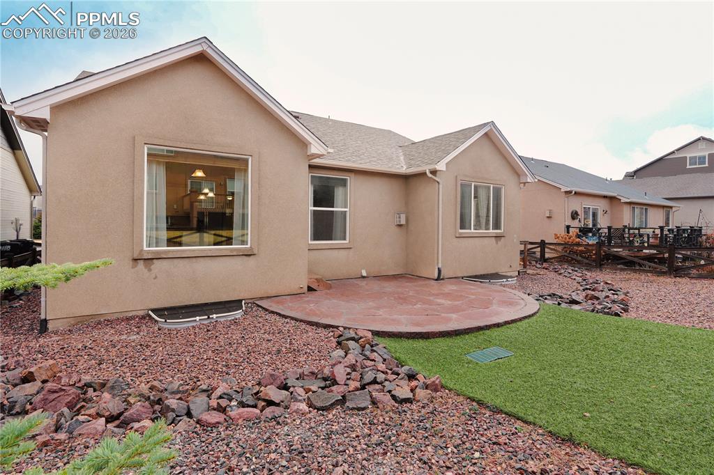 Rear view of house with a patio, stucco siding, roof with shingles, and a deck