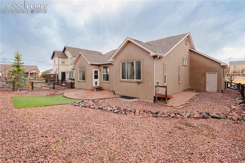 Rear view of property featuring a fenced backyard, a patio area, and stucco siding