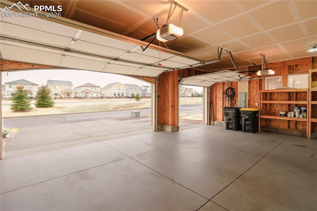 Garage featuring a residential view and a garage door opener