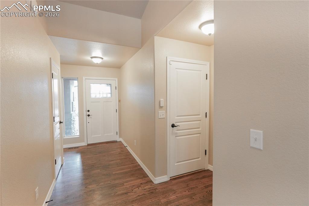Entrance foyer featuring dark wood-type flooring and baseboards