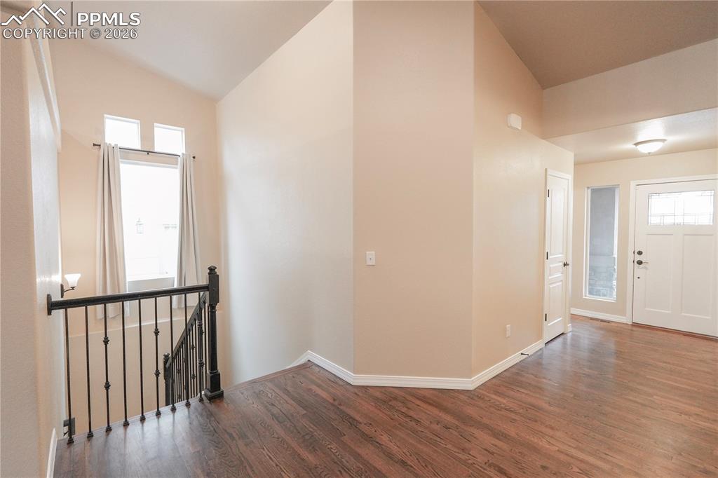 Foyer entrance featuring vaulted ceiling and dark wood finished floors