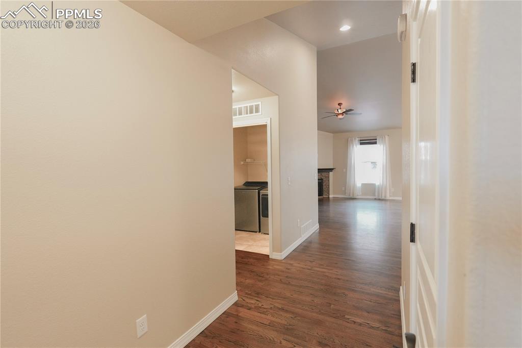 Hallway featuring dark wood finished floors, independent washer and dryer, and recessed lighting