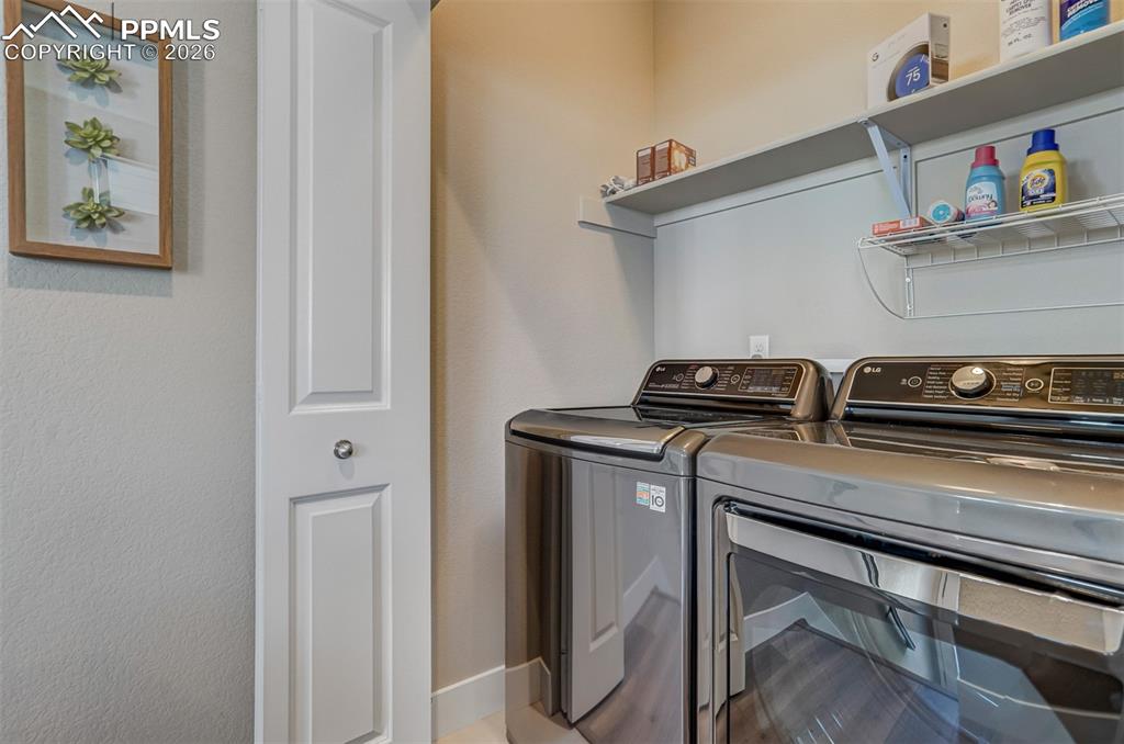 Laundry area featuring washing machine and clothes dryer and baseboards