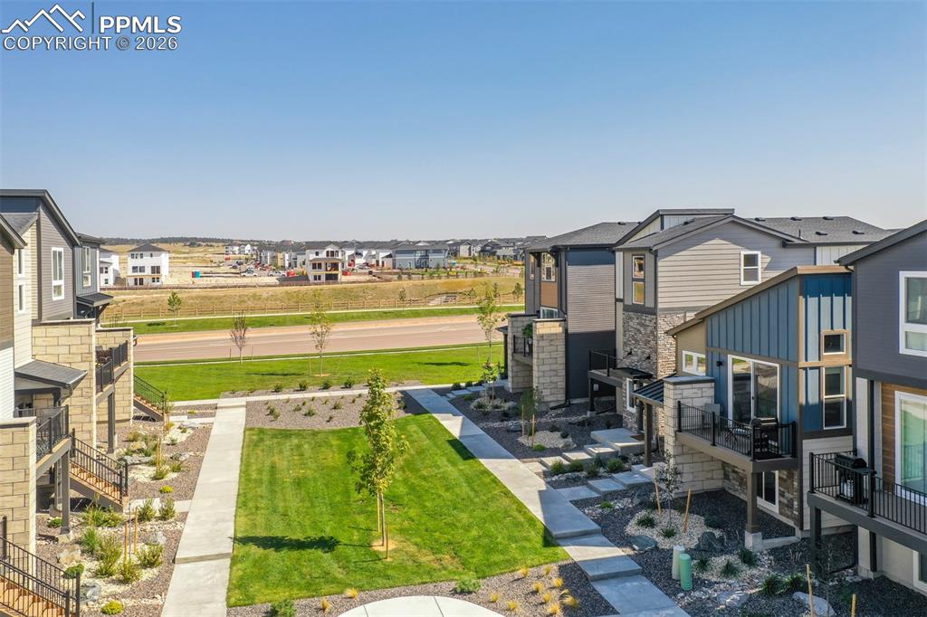 View of grassy yard with a residential view and stairs