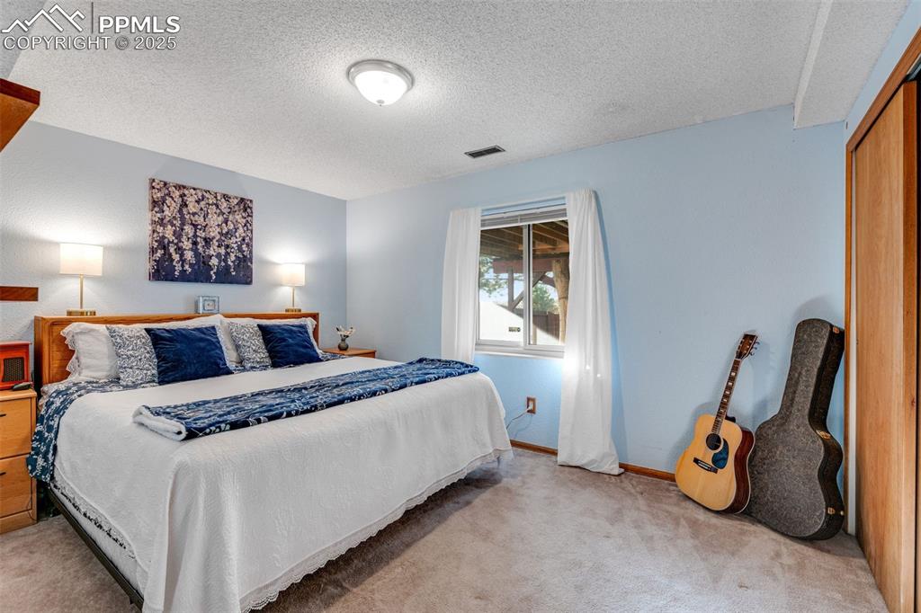 Bedroom with carpet floors and a textured ceiling