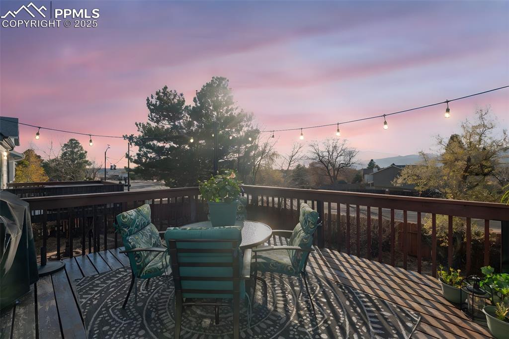 Wooden terrace featuring outdoor dining space and grilling area