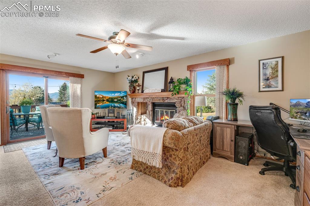 Spacious living room with wood burning fireplace and deck access. 