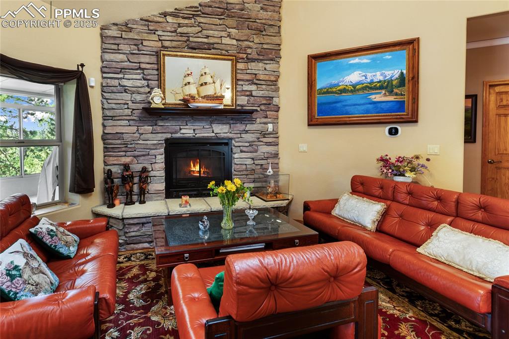 Living area with a stone fireplace and lofted ceiling.