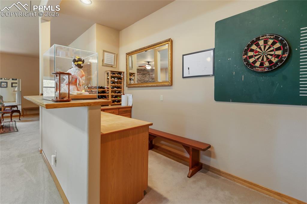 Dry bar featuring tile counters and brown cabinets.
