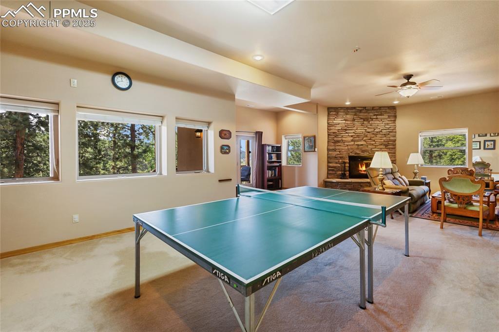 Rec room featuring carpet, a fireplace, a ceiling fan, and recessed lighting.
